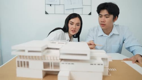Architects Reviewing a Building Model in a Workplace