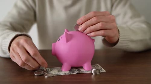 Concept of saving money in a piggybank. Saving coins with both hands.