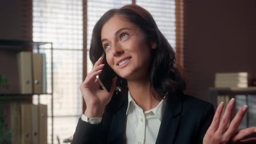Cheerful Woman Talking on Cellphone in Office