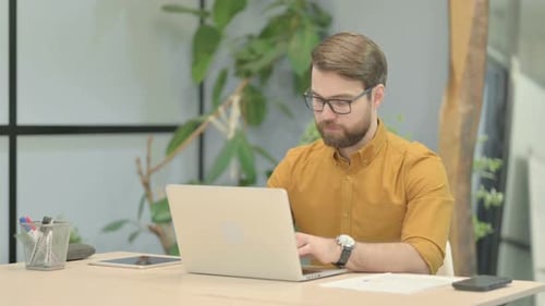 Man Looking Worried While Working on Laptop