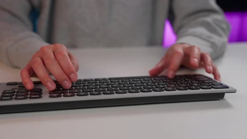 Girl typing on a keyboard in a bright room