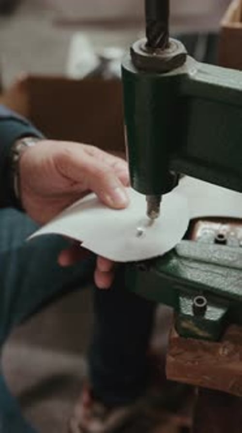 Leather Worker Using Industrial Machine to Punch Holes