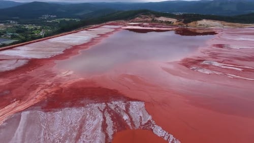 Reflections On Waters Of Red Mud Pond At Alcoa Reservoir In Lugo, Spain. aerial shot