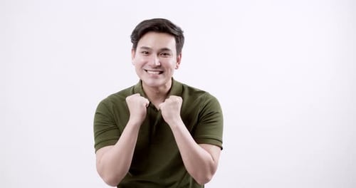 Excited Young Man in Olive Green Shirt Celebrating Self-Made Success