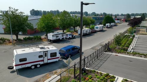 Caravan Trailer Towed Behind A Blue Car At Rest Area In Mission, BC, Canada. - aerial shot