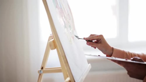 Woman Painting with Palette Knife on Canvas Easel