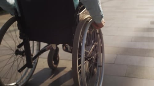 Hands Moving Wheelchair on Street Disabled Person Outdoor