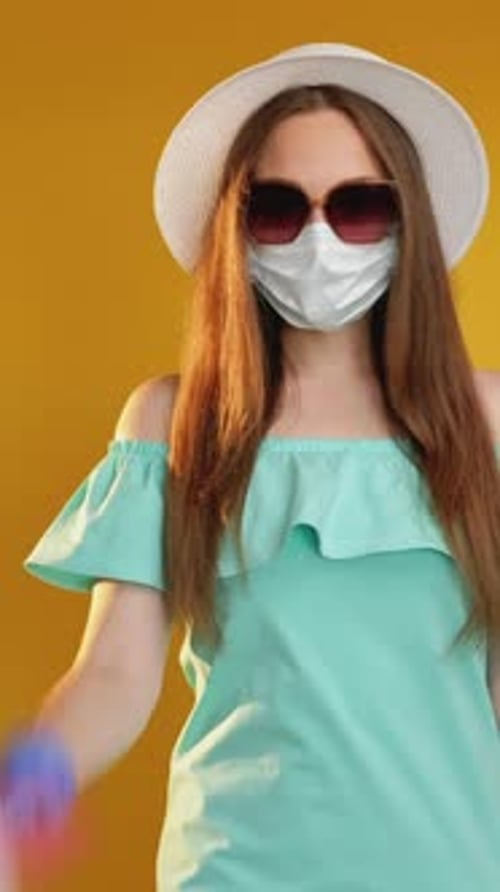 Young Woman Holding Passport and Ticket Wearing Mask