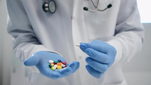 Doctor Holds Colorful Pills in Gloved Hands