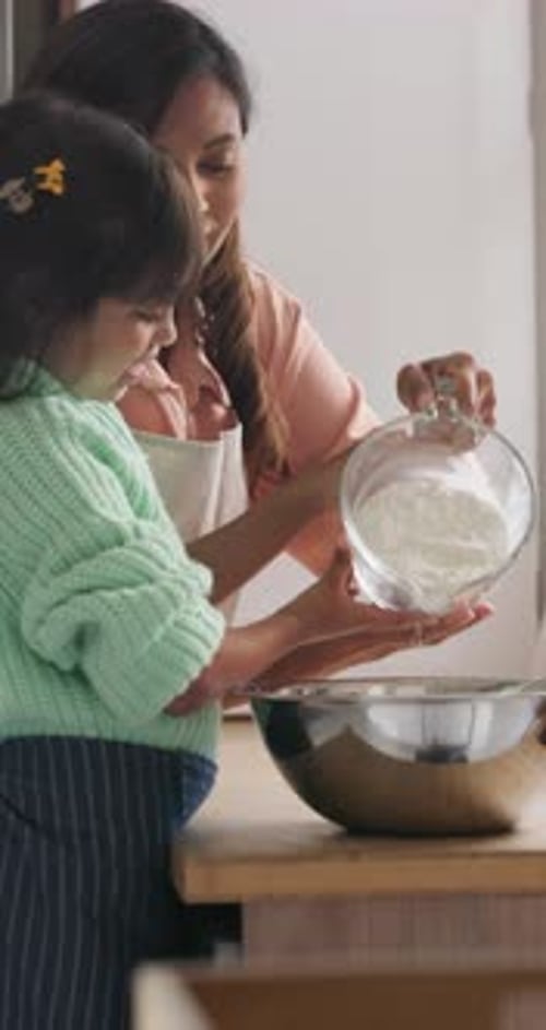 Child Helps Adult Prepare Food in Kitchen