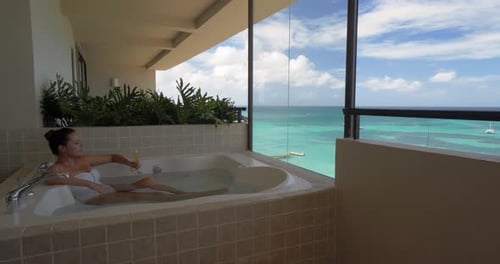 Beautiful Woman in Hot Tub Overlooking Tropical Ocean Alone