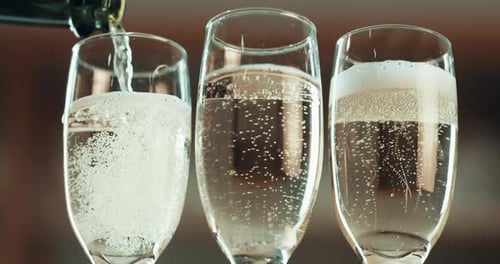 Champagne Poured into Three Elegant Champagne Glasses