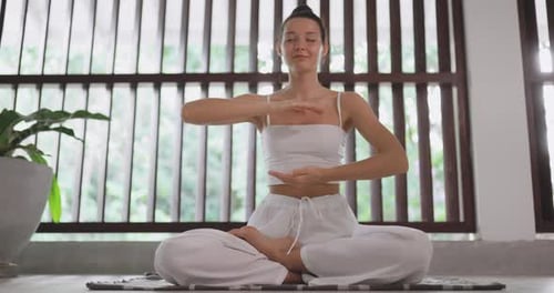 Woman Meditating in Yoga Pose Indoors