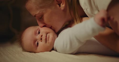 Caring Mother Kisses Adorable Infant on the Head