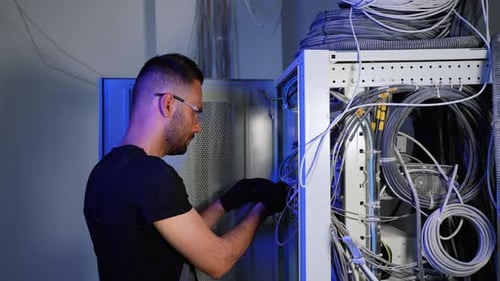 Technician Working on Server Cables in Data Center