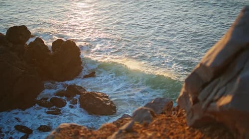 Splashing Waves Covering Rock at Sunset Closeup Cold Sea Water Foaming Evening