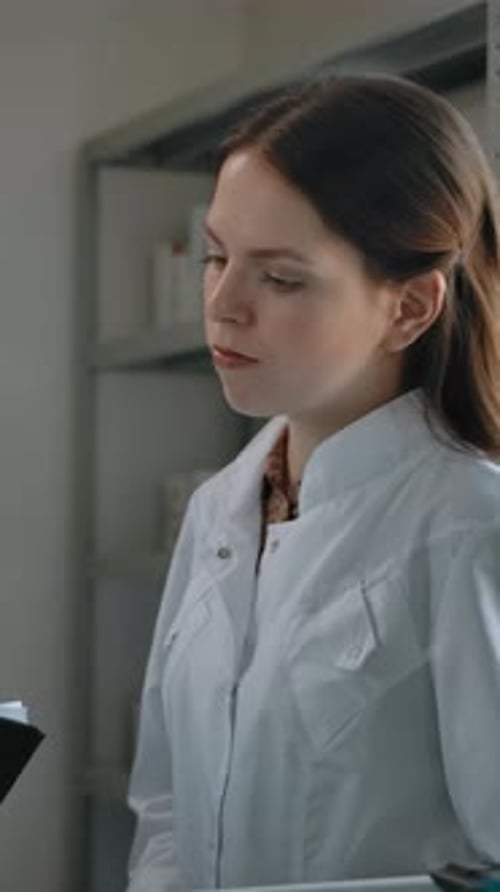 Vertical of Middle Shot of Two Pharmacists Talking About Medicine Indoor of Drug Store