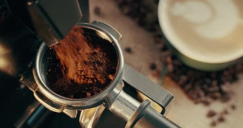 Machine, ground and coffee with grinder at cafe for beans, strong caffeine or dark roast above