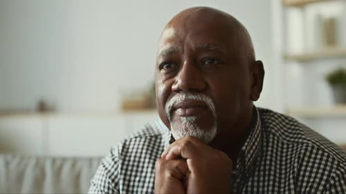 Senior man contemplates in quiet interior setting