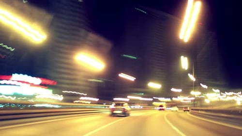 Night city traffic time lapse driving along a busy urban highway