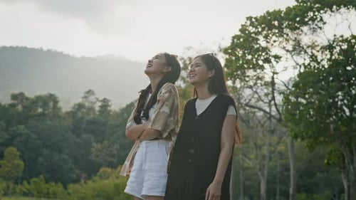 Two Young Women Laughing Together in a Park