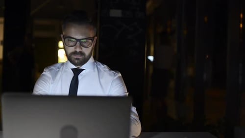 Late night grind handsome businessman works overtime in modern office