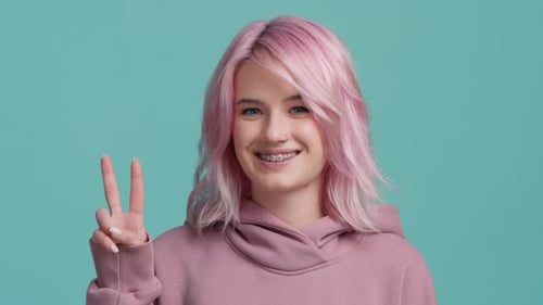Smiling Woman with Pink Hair Makes Peace Sign