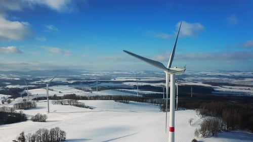 Aerial View of Winter Meadow with Wind Turbines Generating Electricity