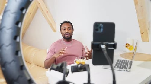 Sociable Guy Creating Video Content Using Smartphone View Through Ring Lamp