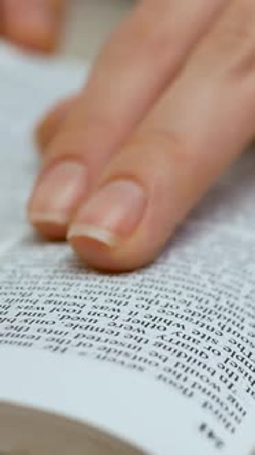 Die Hand einer Frau schließt das Buch zum Abschluss der Bibel