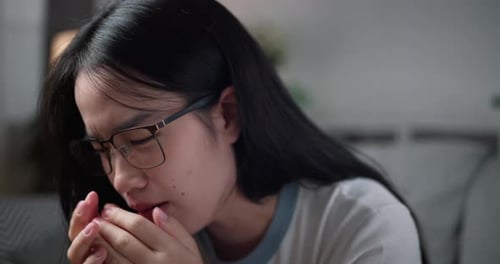 Young Woman Coughing into Hands Close Up