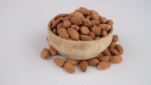 Wooden Bowl Full of Almonds on White Background