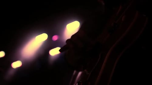 Guitarist Playing Electric Guitar on Stage at Night