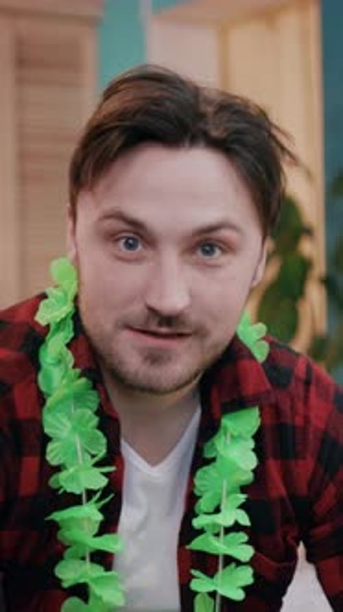 Man Wearing Shamrock Lei Smiles Indoors