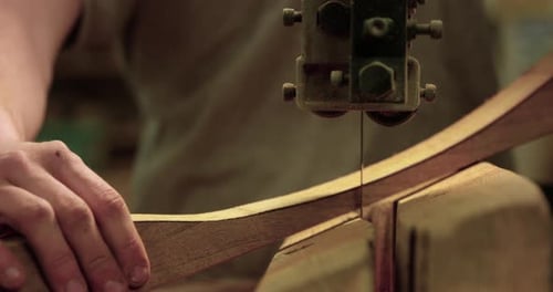 Band saw cutting through piece of wood - close up - slow motion