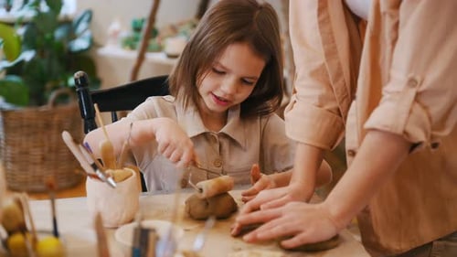 Child Sculpting Clay with an Adult in Home