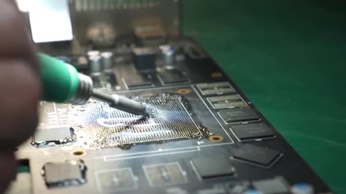 Close Up of Soldering Iron Repairing Circuit Board