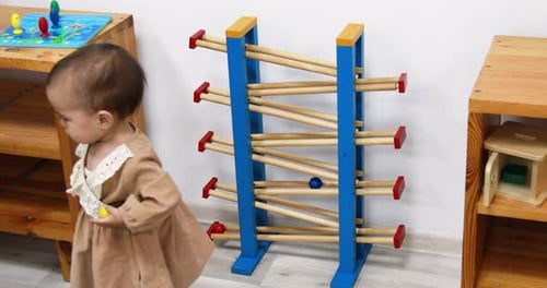 Infant Playing with Wooden Ball Run Toy