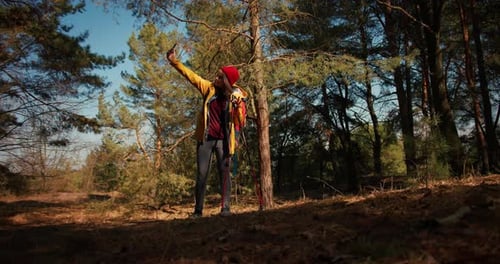 Backpacker Hiker Girl with Hiking Poles Walking Between Trees in a Mountain Forest Hispanic Teenager