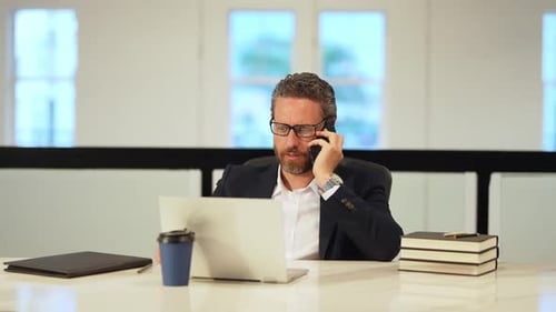 Office Worker Talking on Phone Working with Laptop Business Man Have Phone Meeting at Office