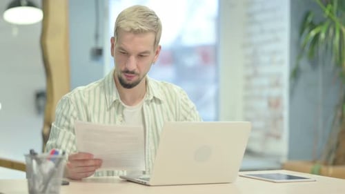Young Man Doing Paperwork in Office