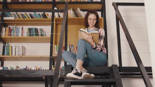 Young Woman Student Reading a Book in the Library or Classroom Interested Reading a Book Students in