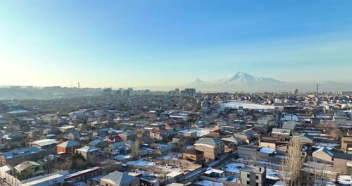 Aerial view A snowy Yerevan Armenia cityscape with a few houses and a few cars
