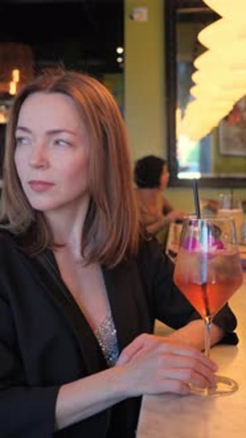 Stylish Woman Posing at Bar with Cocktail