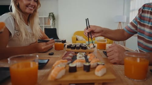 Group of friends eating sushi together at home.