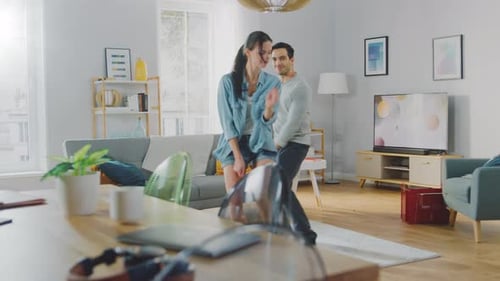 Happy Couple Dancing Together in Living Room