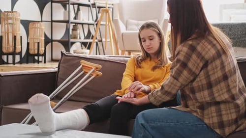 Teen Girl with Cast Comforted by Woman