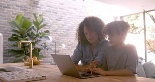 Woman and Child Using Laptop in Modern Kitchen