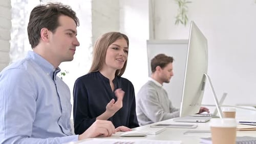 Attractive Startup Team doing Video Chat on Desktop in Office