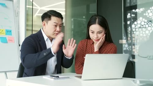 Colleagues Collaborate on Laptop in Modern Office